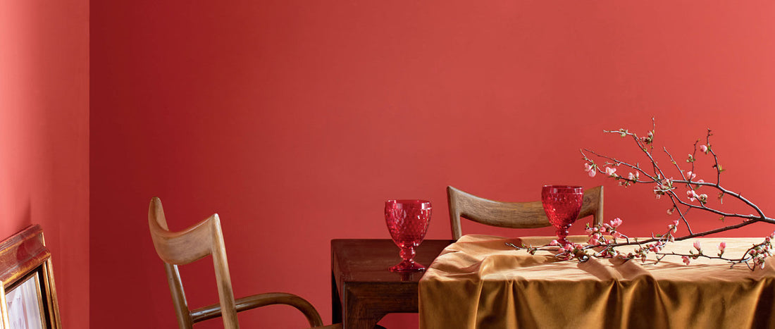 a dining room table with a red accent wall