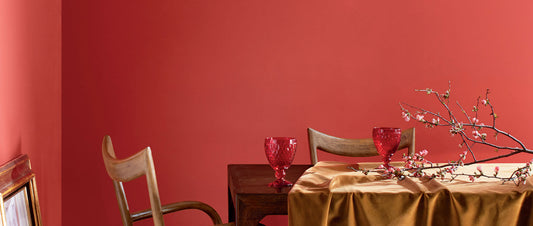 a dining room table with a red accent wall