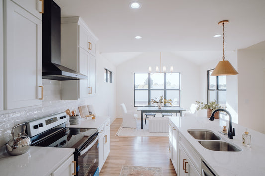 a white kitchen with oak wood flooring