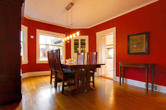 A dining room painted red with a wood table and chair set at Red Star Paint near Montclair, New Jersey