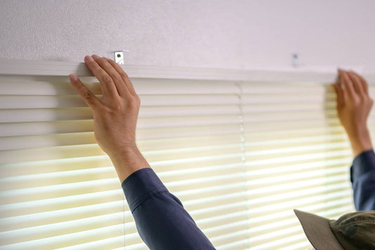 Someone installing white horizontal blinds on a window at Red Star Paint & Decorating Center at Red Star Paint near Montclair, NJ