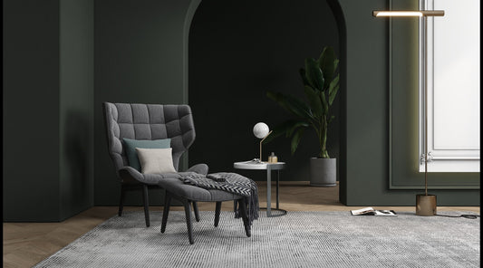 an accent chair with a dark grey accent wall