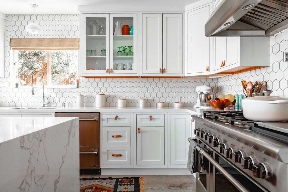 a remodelled kitchen with white cabinets and counter tops