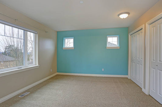 An empty room in a new home with a bright blue-green accent wall at Red Star Paint near Montclair, New Jersey