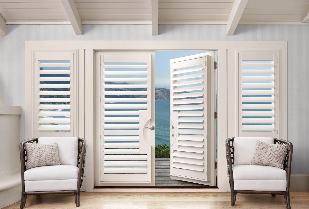 two white chairs sitting in front of a white door